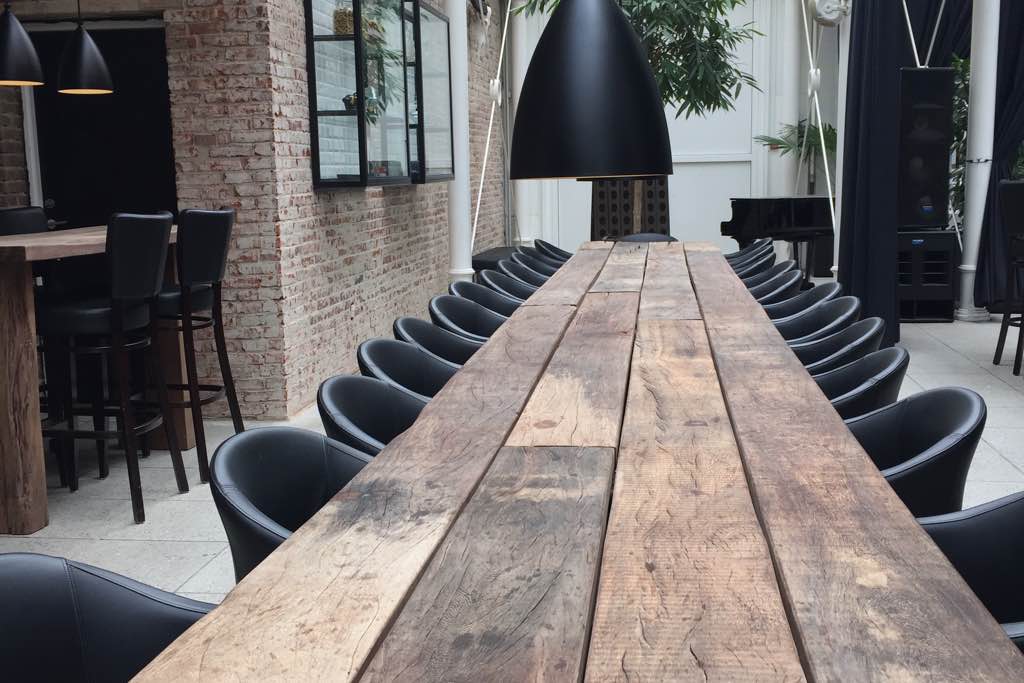 großer, langer Esstisch im Restaurant aus Naturholz