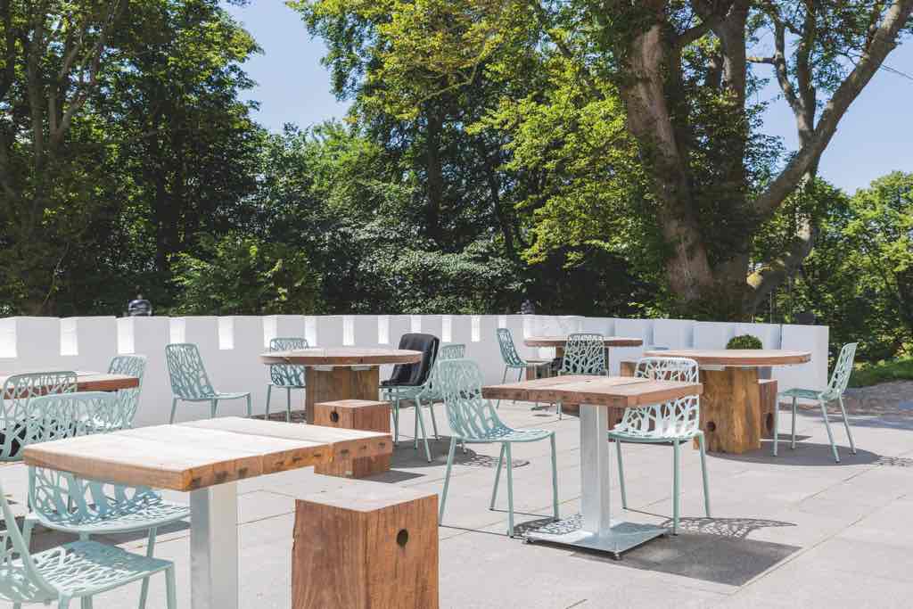 Bistrotische auf einer REstaurant-Terrasse als Sonderanfertigung aus Holz und Metall
