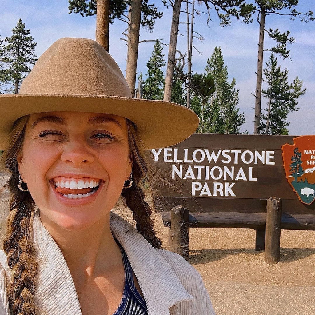 Court standing in front of the Yellowstone National Parks Sign