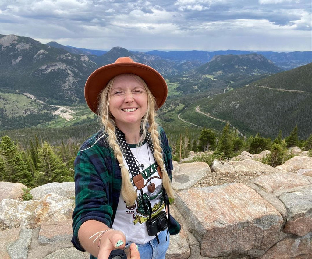 Judy wearing the Shop Tee in front of mountains