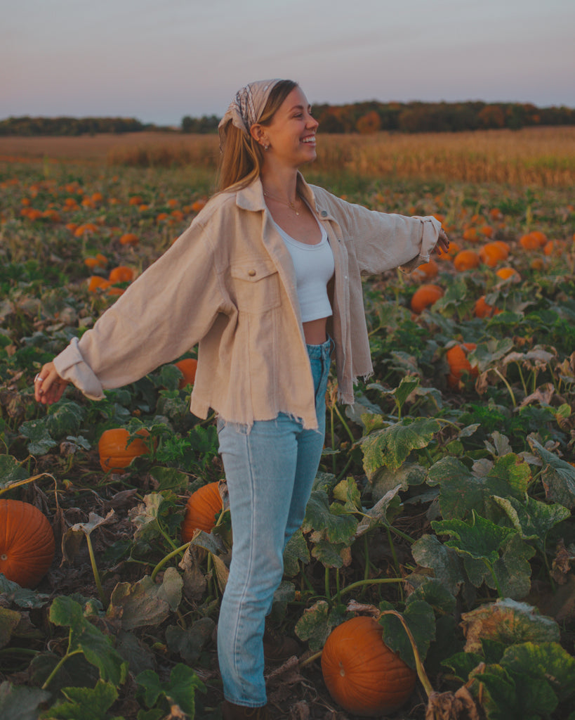 Courtney standing in a pumpkin patch