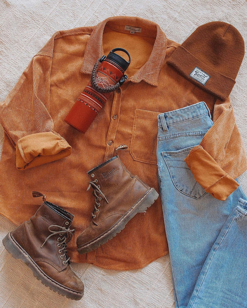 Flatlay of corduroy, jeans, boots and beanie.
