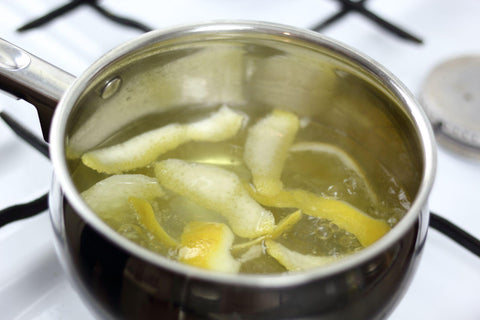 Boiling lemon peels in saucepan.