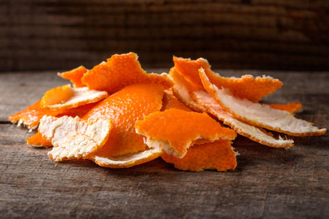 Fresh orange peels on wood