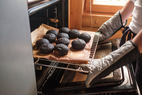 Woman holding a tray of burnt muffins