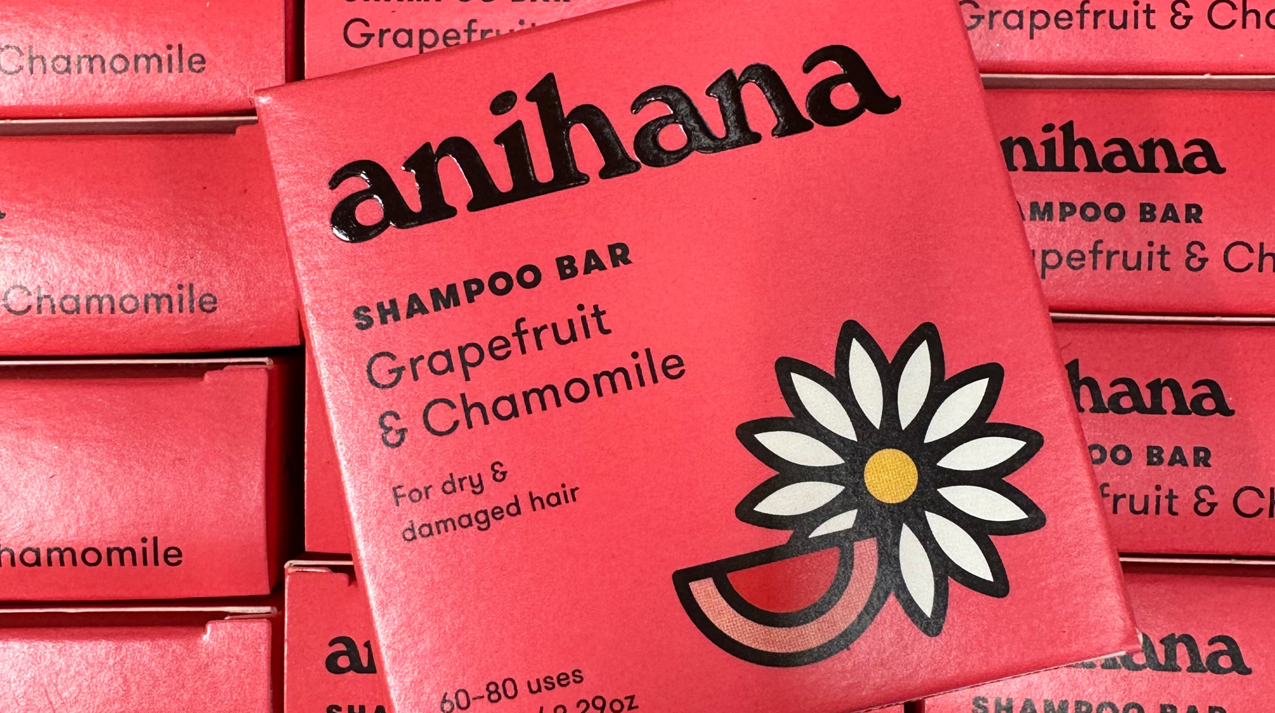 Image shows several redish-pink boxes that say anihana shampoo bar, grapefruit and chamomile, for dry and damaged hair.