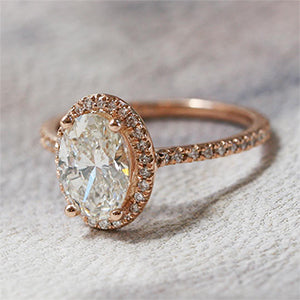 oval diamond engagement ring with diamond halo and pave diamond band in rose gold