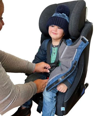 Child wearing Buckle Me Baby Coat while getting buckled into car seat