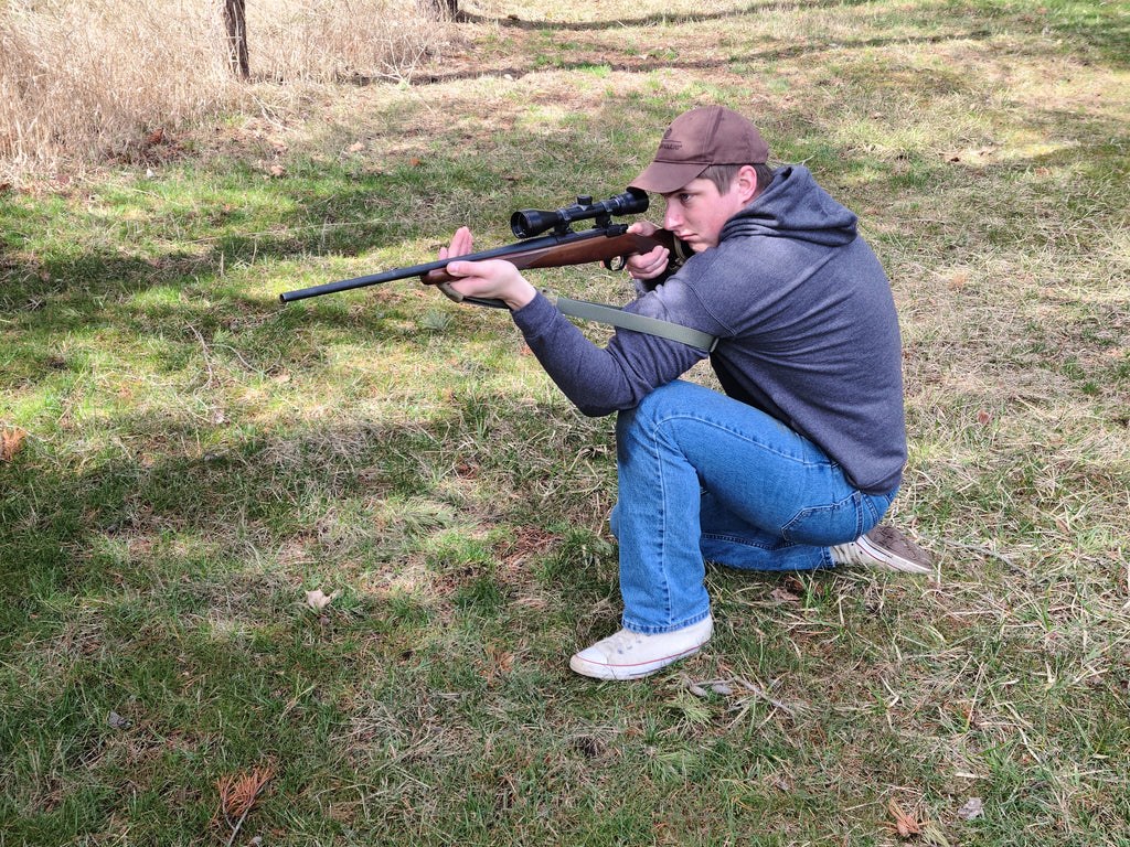 Shooter demonstrating a kneeling position with a green nylon webbing RS-1 Reinforced Loop Sling