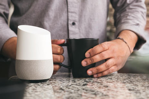 Man with Coffee and Google Home Assistant