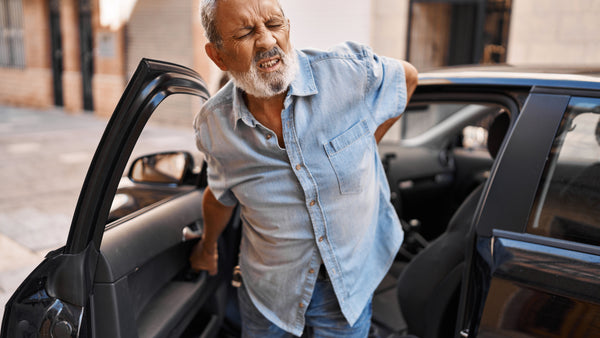 old man with back pain get out of car