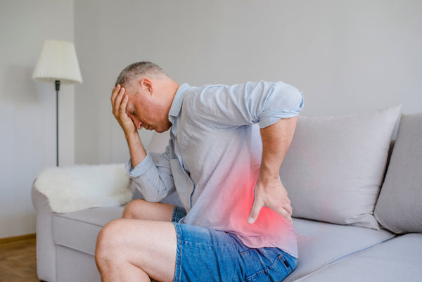 Man feeling extreme back pain after a long day of travel