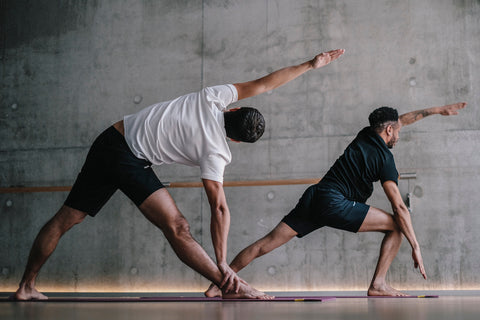 Deux hommes font une posture de yoga