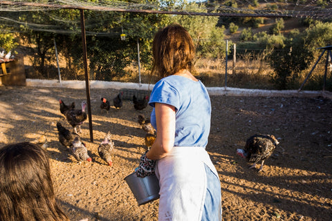 Vrouw voert kippen in haar tuin