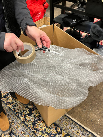 Material som behövs för att packa en sadel. En stadig kartong, bubbelplast eller annat skyddsmaterial, sax och tejp.