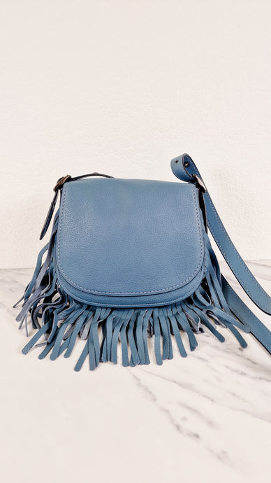 coach fringe saddle bag with pyramid rivets