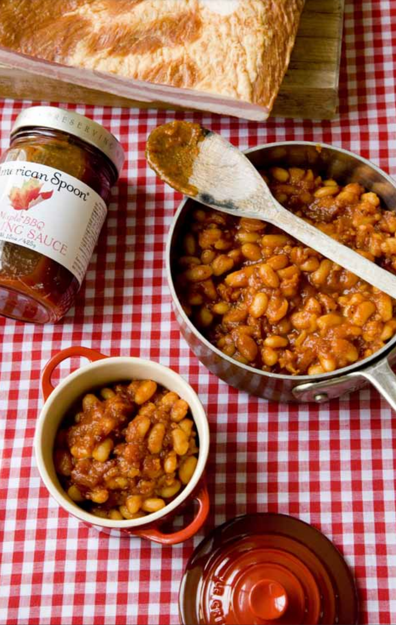 Saucepan of homemade maple baked beans with jar of Maple BBQ 