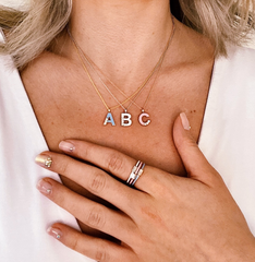 girl with a, b, c necklaces and rings on