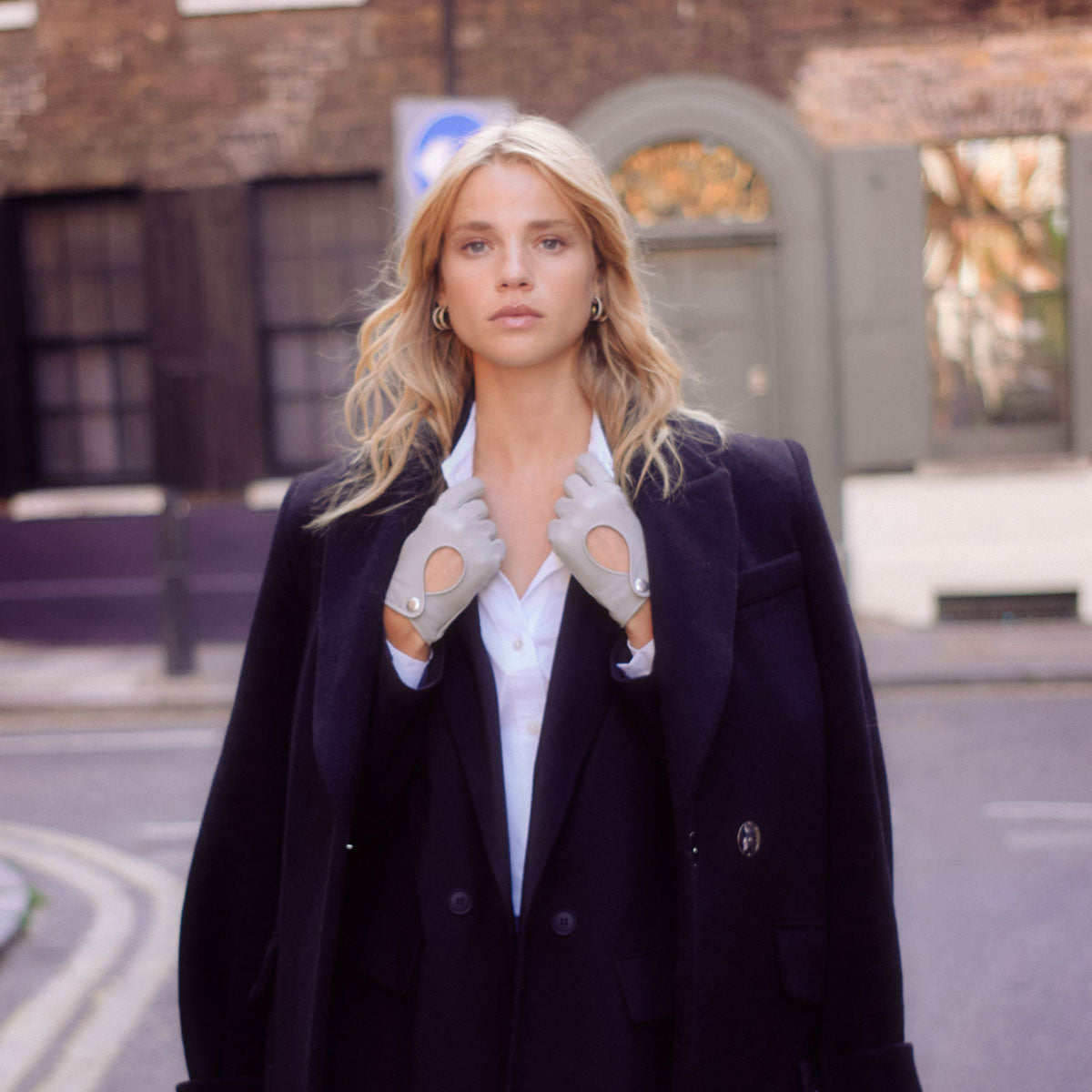 Woman wearing leather driving gloves in dove grey