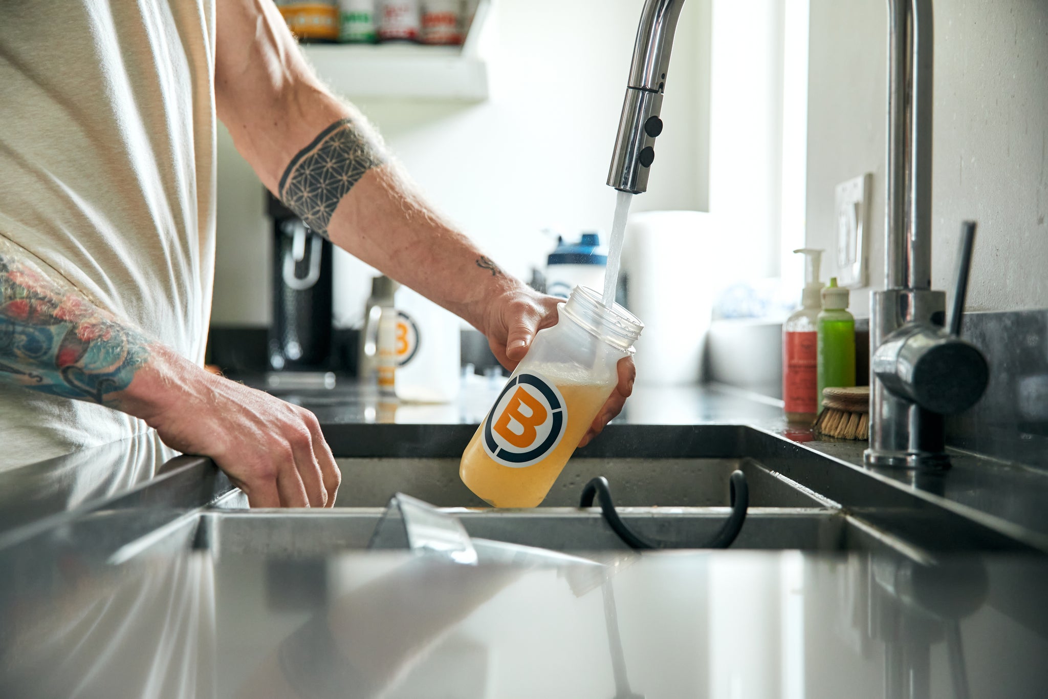 Man filling a bottle with water and Blonyx Hydra+ at a sink