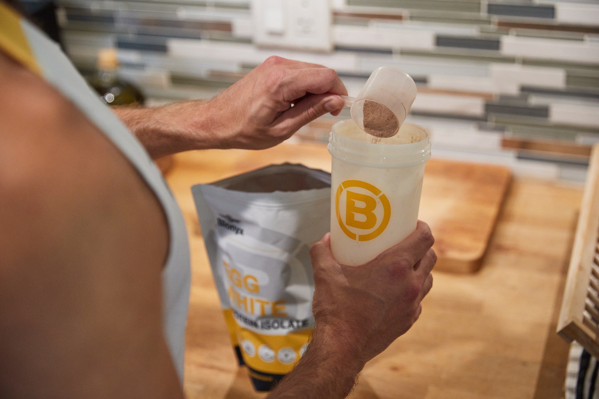 Athlete scooping Blonyx Egg White Protein Isolate out of the bag