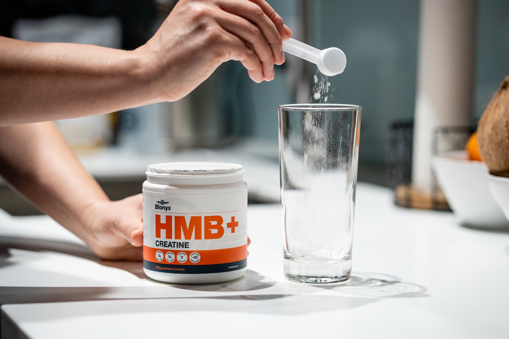 Athlete scooping Blonyx HMB+ Creatine into a glass