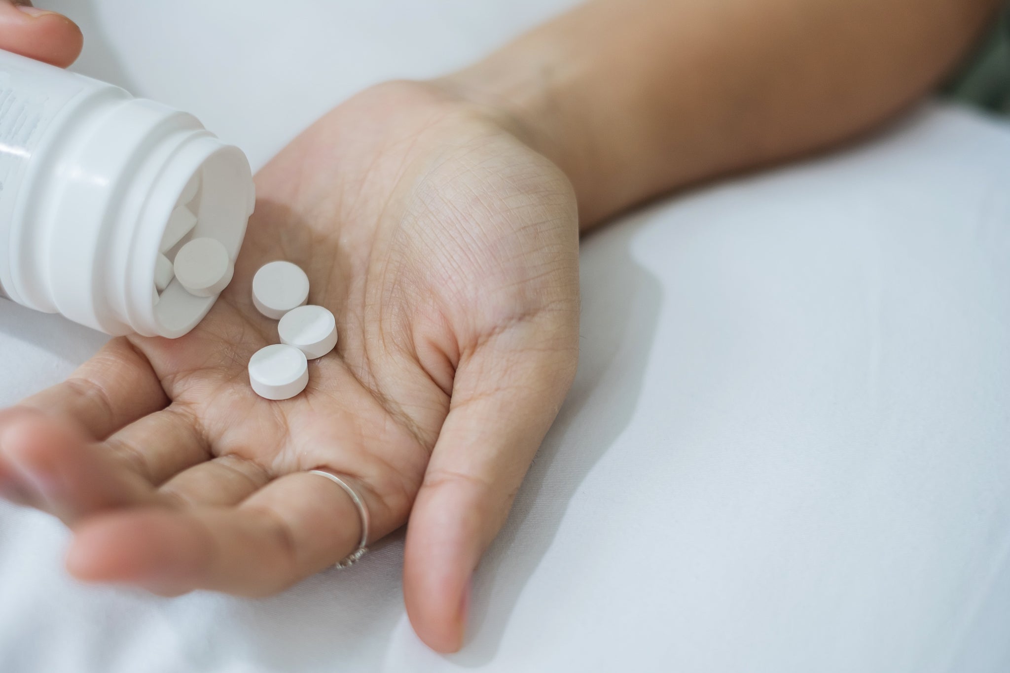 Woman pouring melatonin pills into her hand