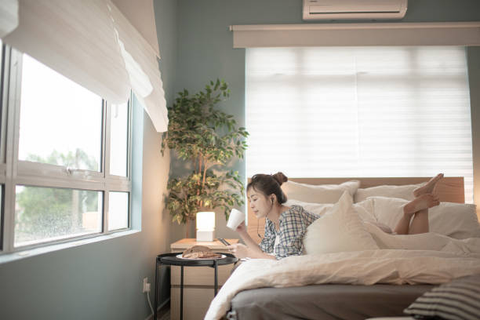  A woman lying on a bamboo bed sheet while sipping coffee