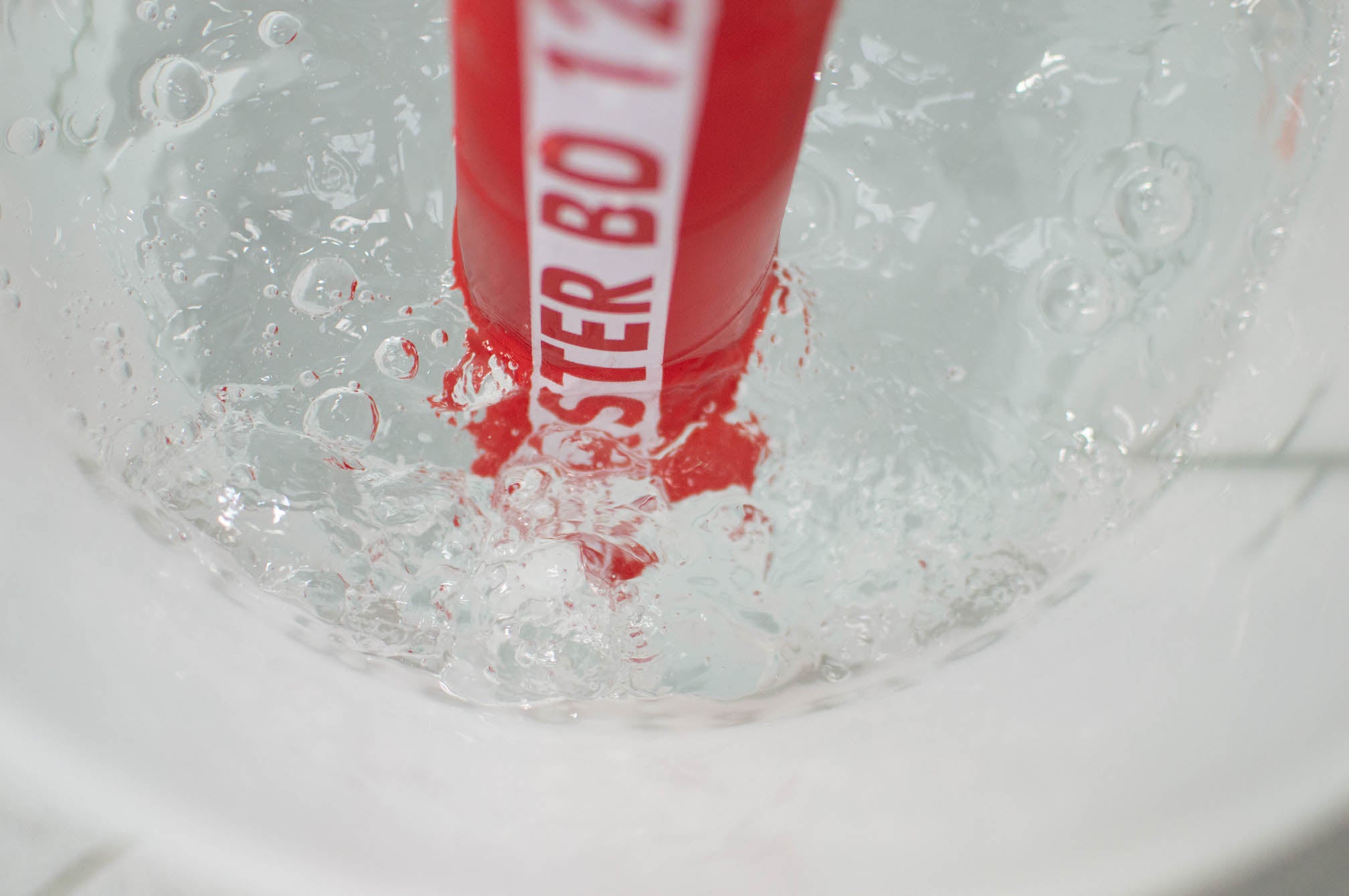 Carbon bubbling from a fermentation vessel into a bucket of water, where it then dissipates into the atmosphere