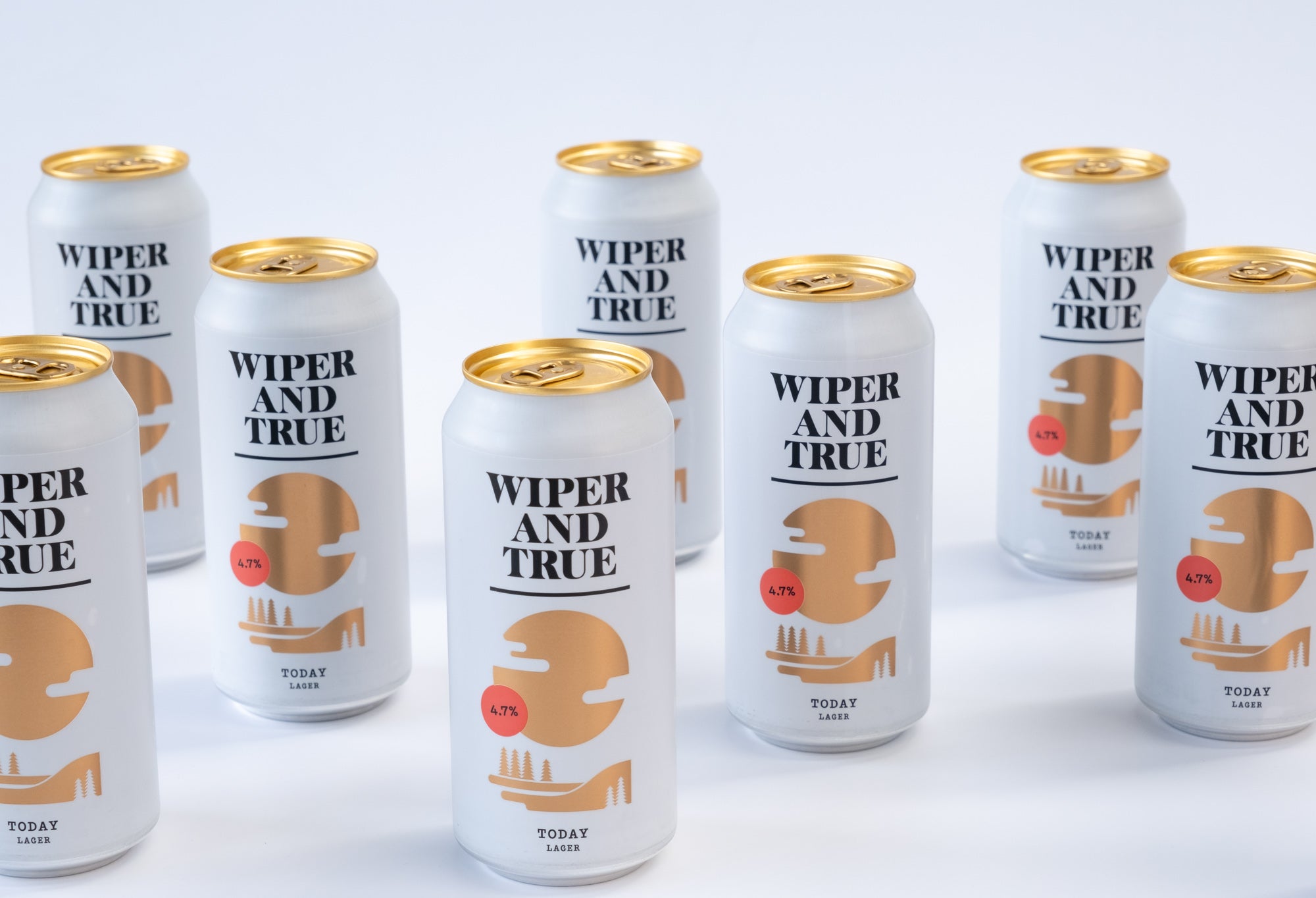 Many cans of Wiper and True lager dotted around against a white background