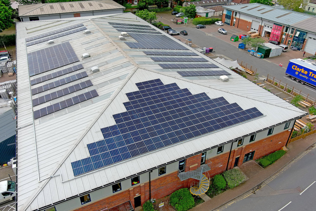 An aerial view of solar panels on a grey roof.