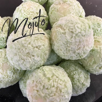 Photo of a pile of Mojito flavoured Belgian chocolate truffles covered in green powder.