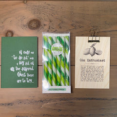 Gin Letterbox gift set comprised of a notebook with gin caption, a set of Gin & Elderflower drinks stirrers and a sign with sayings about Gin