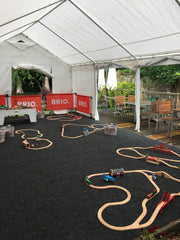 Photo of the PAPILIO Summer Fun tent set up for the BRIO weeks. Lots of individual BRIO track circuits can be seen set up in the tent.