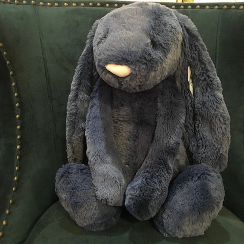 Huge Navy Bashful bunny from jellycat sitting in a chair
