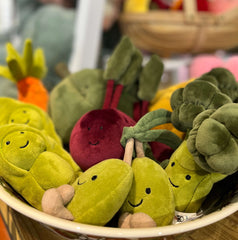 Photo of a bowl of Jellycat Vivacious Vegetables cuddly toys. Peas, radish, carrot, broccoli, olives and squash can be seen.