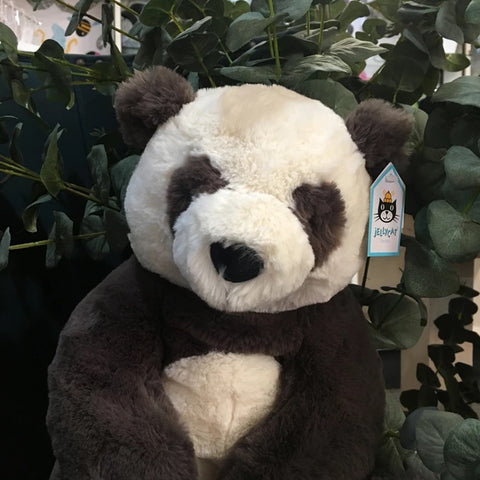 Photo of Jellycat Harry panda cuddly toy in amongst fake eucalyptus.