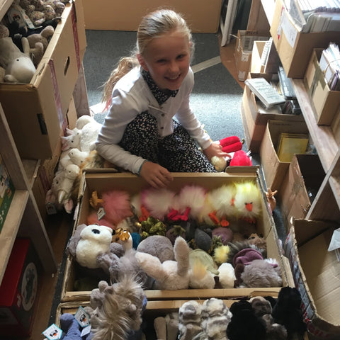 Photo of a nine year old girl in the shop stock room, sorting the boxes of Jellycat