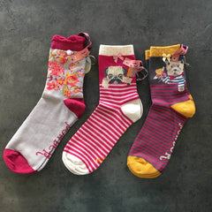 Trio of ankle socks by Powder design. One is grey with pink and orange flowers. The second is pink striped with a pug and third is purple striped with a westie dog. 