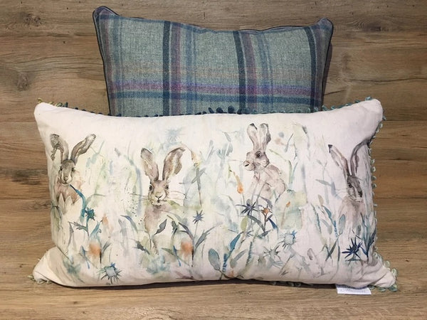 Photo of the four hares cushion in a watercolour illustration style.