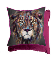 Image showing the 43x43cm Kendi Cushion by Louise Luton. The painting that has been reproduced on the cushion is a lion face ‘Kendi’. The image is made up of lots of vibrant colours including turquoise, pinks and purples. His nose is purple. Within the markings are some tribal shapes. Behind the cushion is an image showing part of the reverse which is a solid, rich plum purple colour. The cushion has matching plum piping.