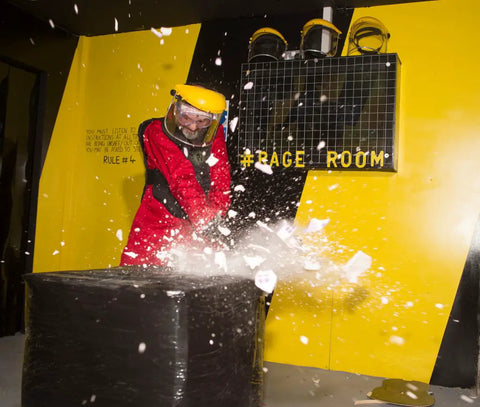 a person in safety goggles smashes something made of porcelain with a hammer