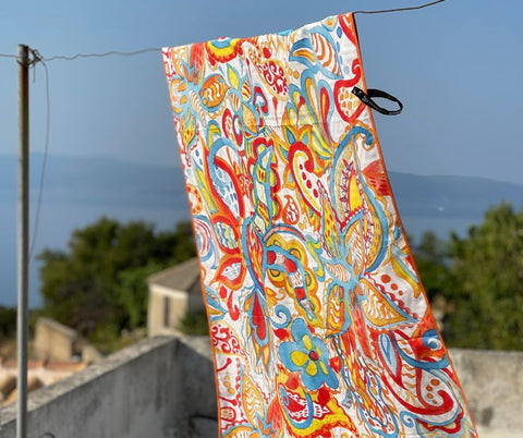 ECCOSOPHY Quick dry Microfiber beach towel hanging on a close line to dry.