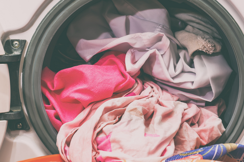 a washing machine filled with pink clothes