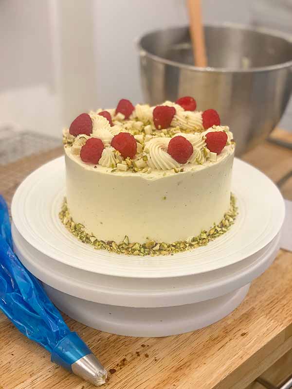 Decorating a simple birthday cake with buttercream, chocolate, fruit and nuts
