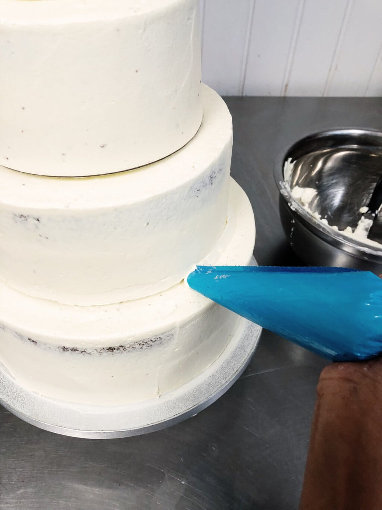 Pipe buttercream on edges on base of cake tiers