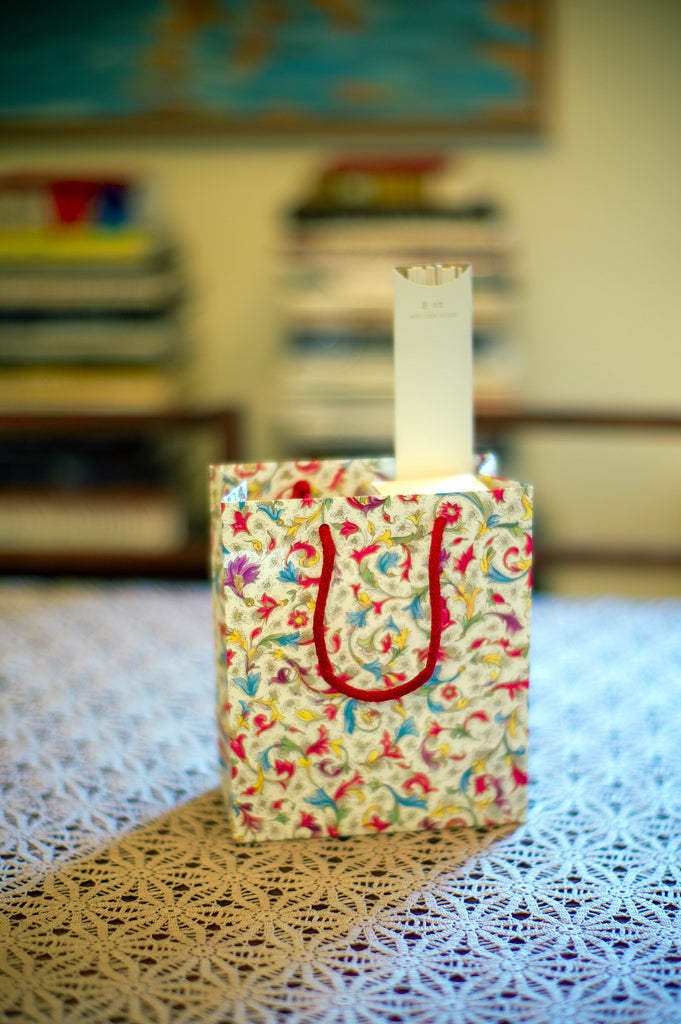 Patterned gift bag with diffuser sticks packet popping out the top