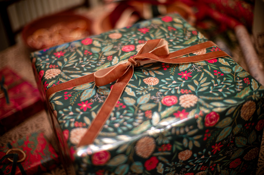 Gift wrapped in green patterned paper and tied with a brown velvet bow