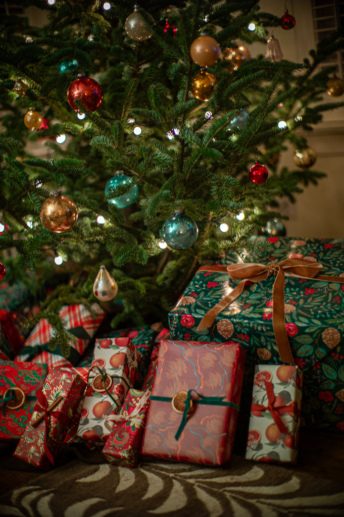 A variety of vintage-wrapped gifts underneath a Christmas tree