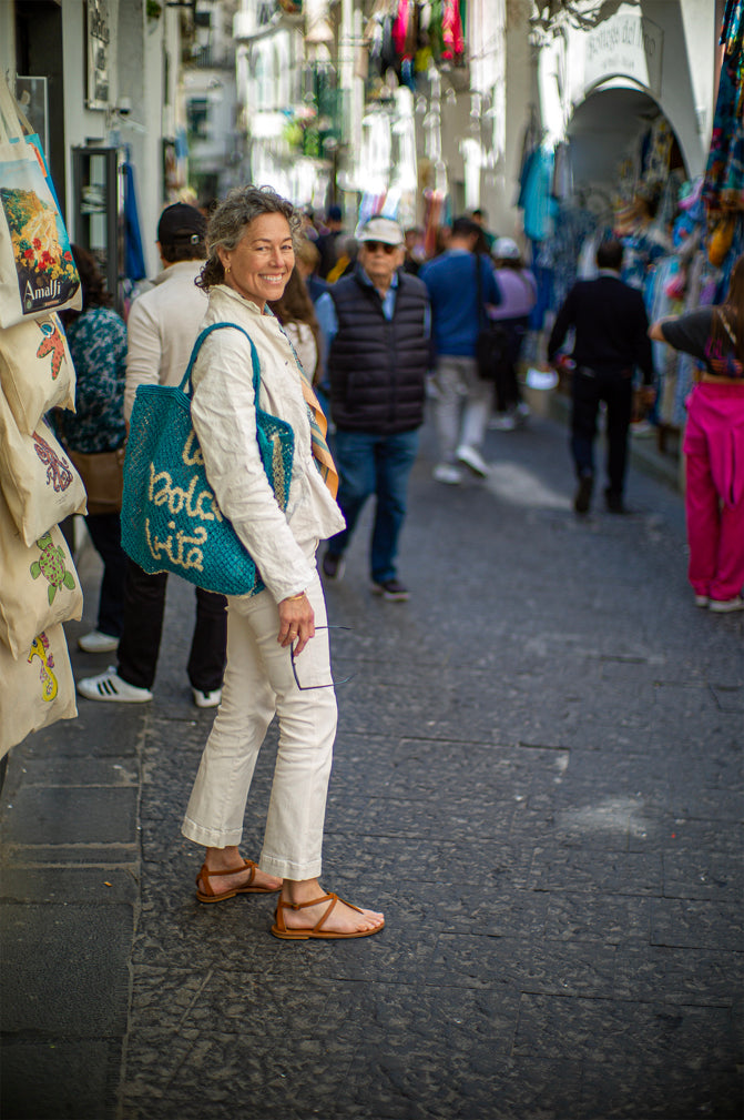 Woman smiling and standing in a busy street in Italy